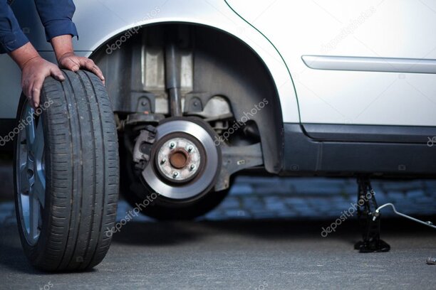 Mechanik wymieniający koło w samochodzie na oponę zimową